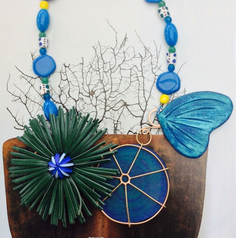 Collier ornemental, feuille de capucine et aile de papillon en papier mâché teinté en bleu, fleur en cuir frangé
